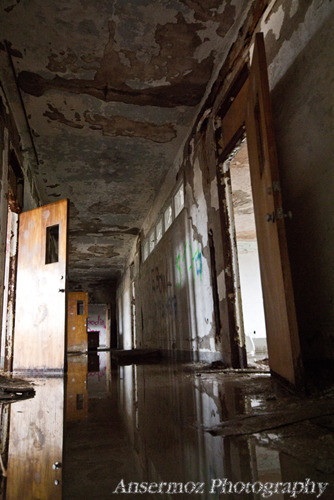 Abandoned school corridor with damaged walls