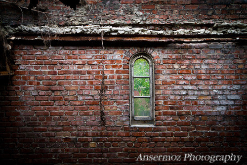 Window on a brick wall in abandoned factory