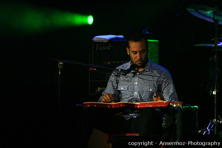 Ben Harper playing slide guitar on stage Ben Harper playing slide guitar on stage