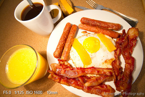 Breakfast with coffee, orange juice, bacon, sausages, eggs