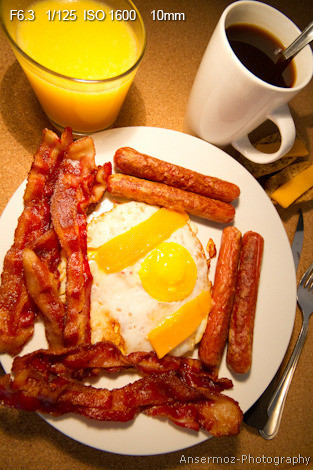 Breakfast sausages on plate with bacon and eggs